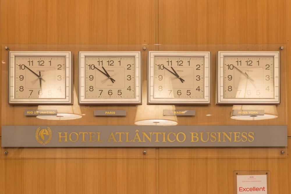 Hotel Atlântico Business Centro Río de Janeiro Exterior foto The photo displays a wooden wall featuring three wall clocks. Each clock shows a different time, indicating that they are set to various time zones. Below the clocks, there is a sign that reads "HOTEL ATLÂNTICO BUSINESS." There are also two lamp fixt
